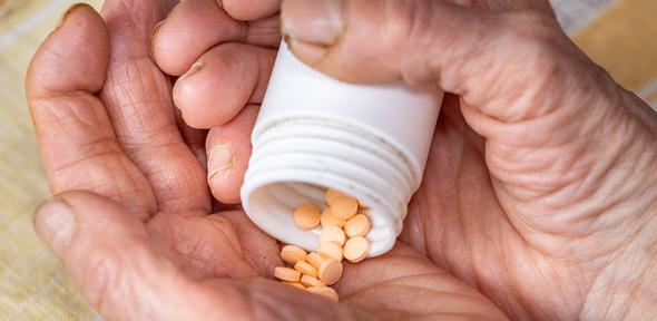 Elderly Woman's Hands and Orange Pills