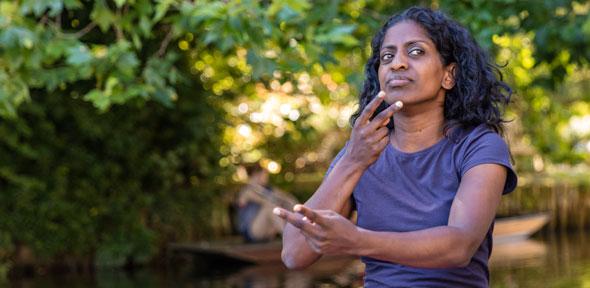 Actress Nadia Nadarajah recites a poem using British Sign Language 