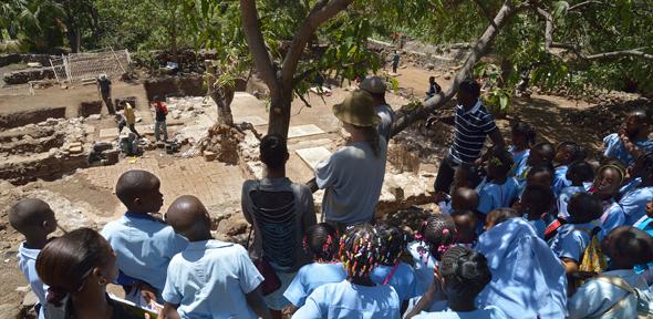 Christopher Evans of the Cambridge Archaeological Unit shows local schoolchildren around the excavation site. 