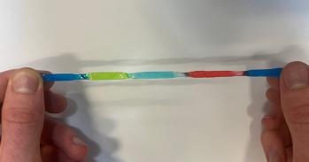 Multi-coloured jelly batteries being stretched by two hands